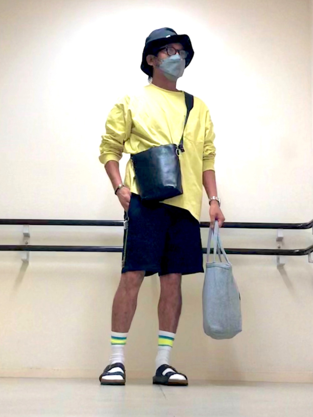 イエロー系のTシャツ/カットソー、ブラック系のショルダーバッグ、ブルー系のデニムパンツを着用したメンズの秋コーディネートの2枚目の写真