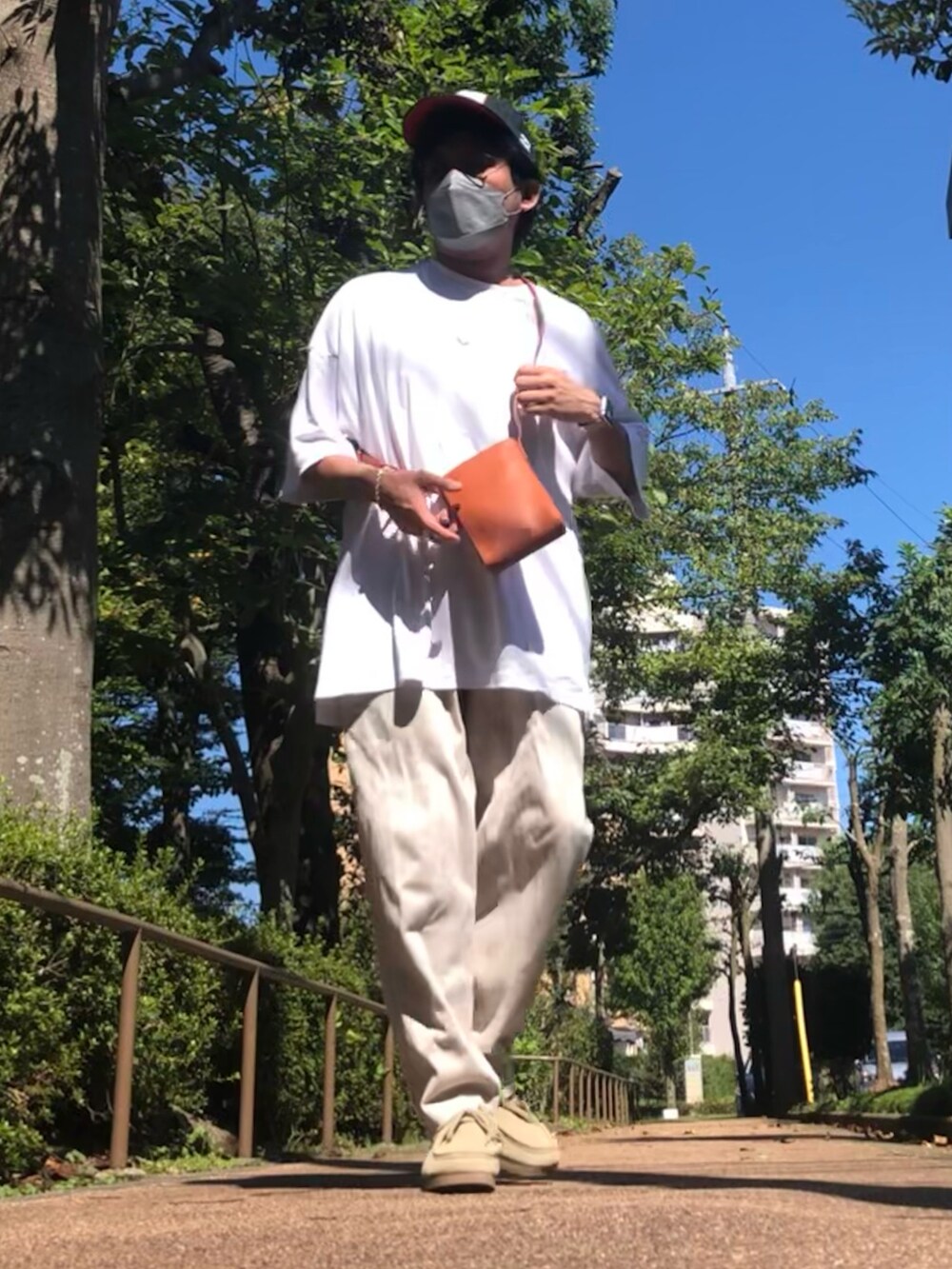 ホワイト系のTシャツ/カットソー、ブラウン系のショルダーバッグ、ベージュ系のスウェットパンツを着用したメンズの秋コーディネートの2枚目の写真