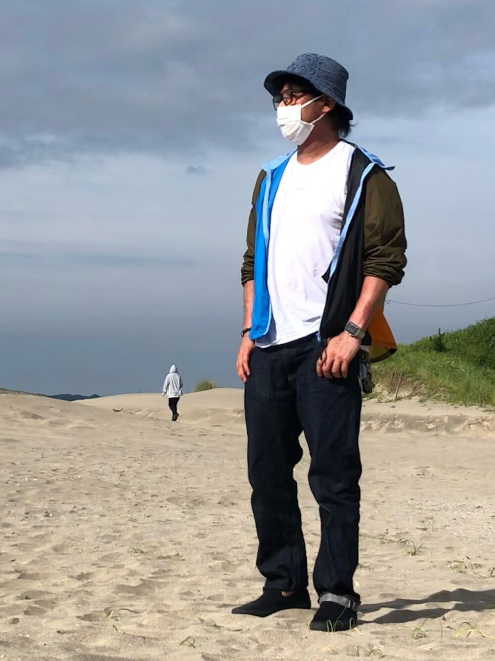 その他のナイロンジャケット、ブルー系のデニムパンツ、ブラック系のスニーカーを着用したメンズの夏コーディネートの5枚目の写真