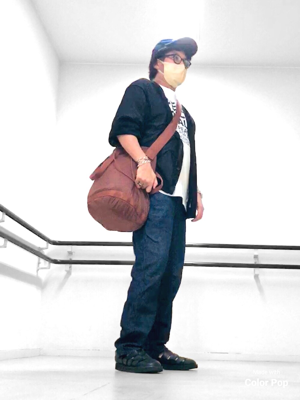 ブラック系のカーディガン/ボレロ、ホワイト系のTシャツ/カットソー、ブラウン系のショルダーバッグを着用したメンズの秋コーディネートの4枚目の写真