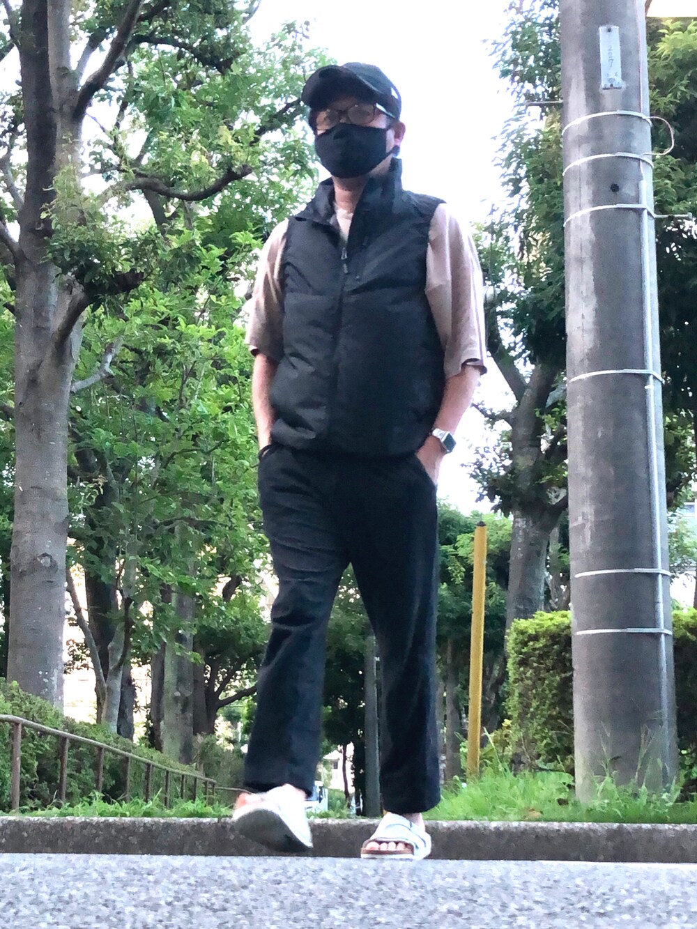 ブラック系のベスト、ベージュ系のTシャツ/カットソー、ブラック系のその他パンツを着用したメンズの夏コーディネートの4枚目の写真