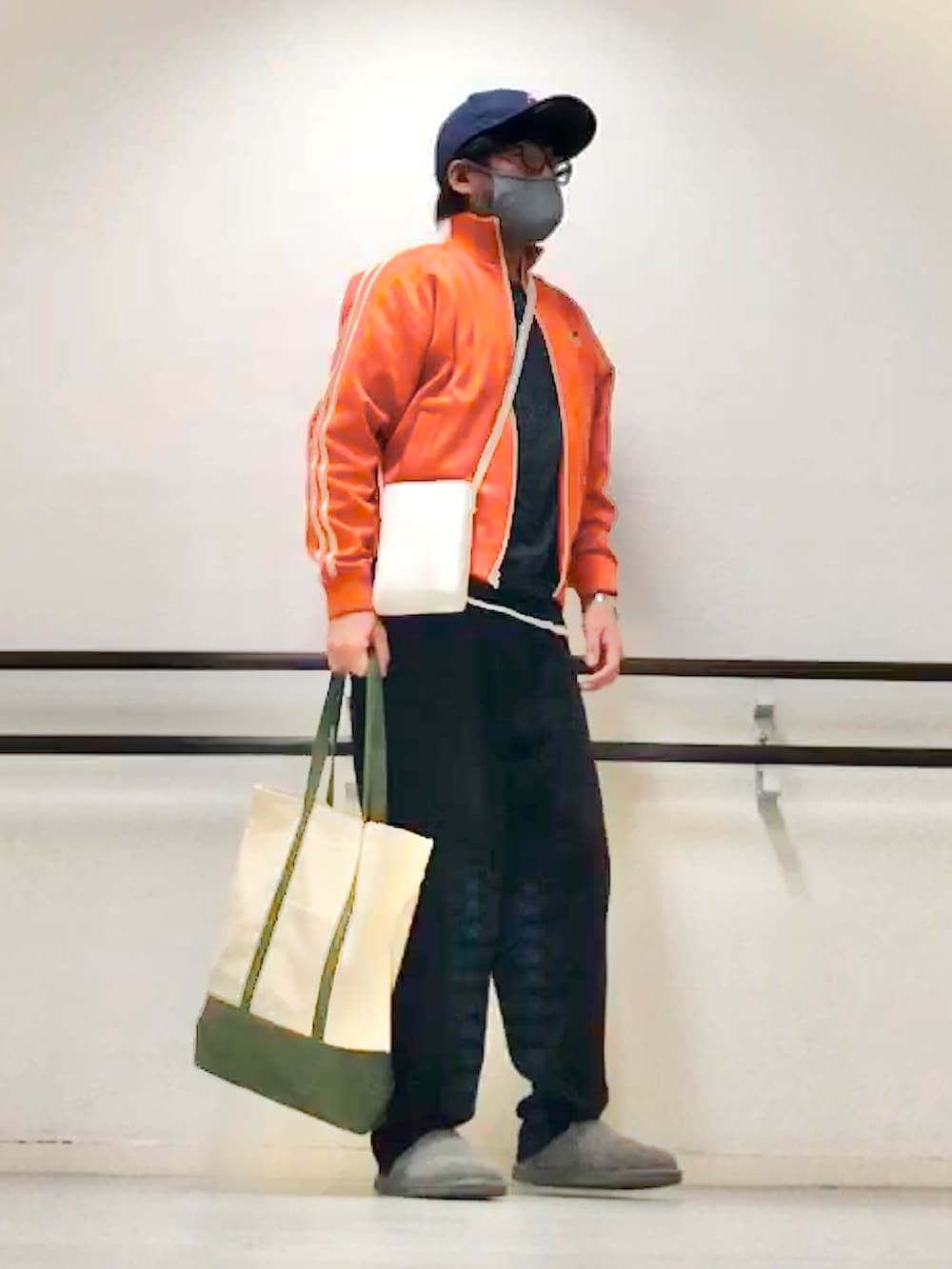 オレンジ系のジャージ、ブラック系のニット/セーター、ブラック系のスウェットパンツを着用したメンズの秋コーディネートの3枚目の写真