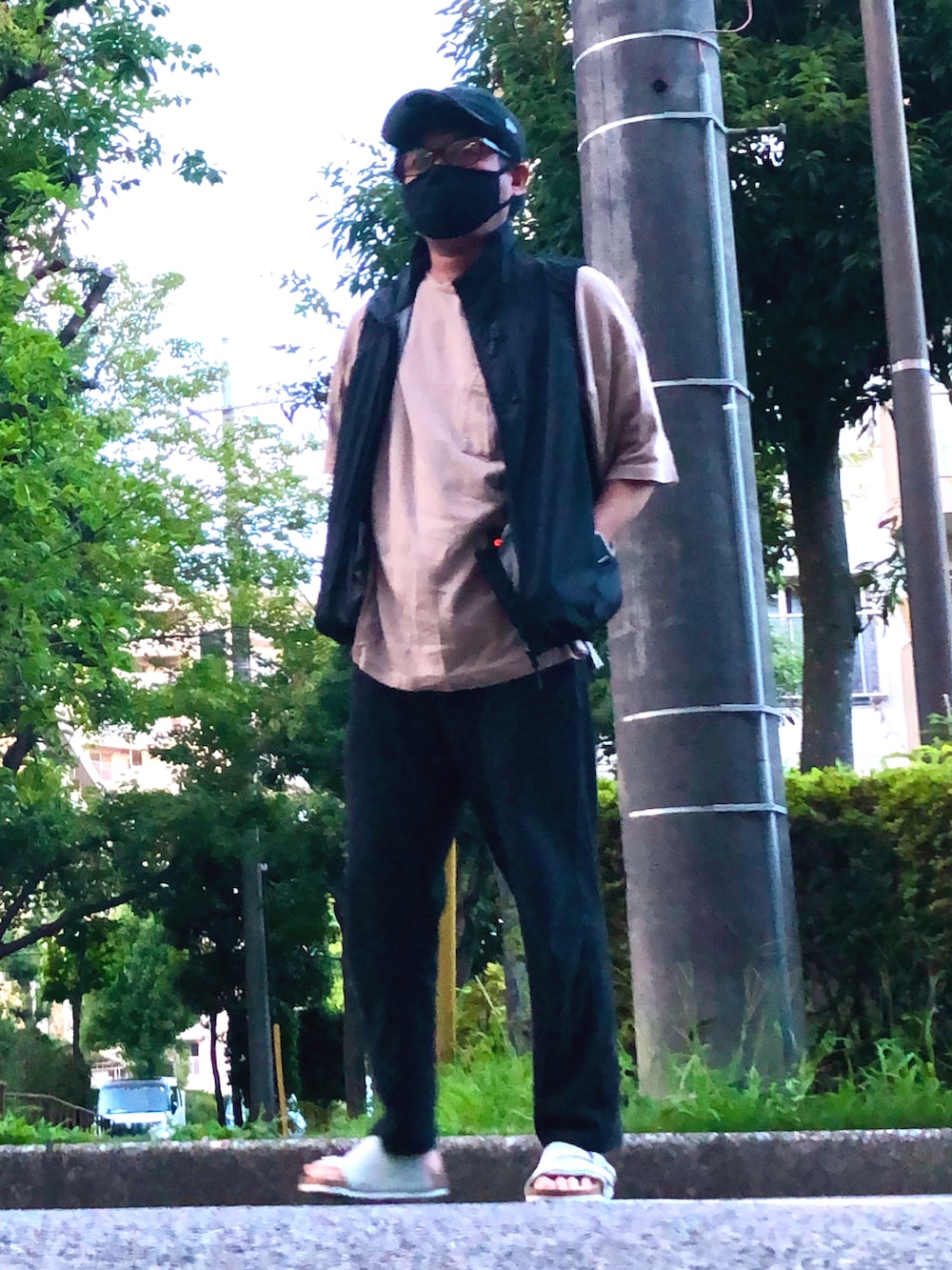 ブラック系のベスト、ベージュ系のTシャツ/カットソー、ブラック系のその他パンツを着用したメンズの夏コーディネートの3枚目の写真