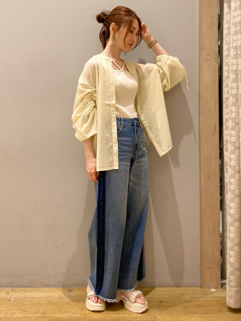イエロー系のシャツ/ブラウス、ブルー系のデニムパンツ、ベージュ系のサンダルを着用したレディースの春コーディネートの2枚目の写真