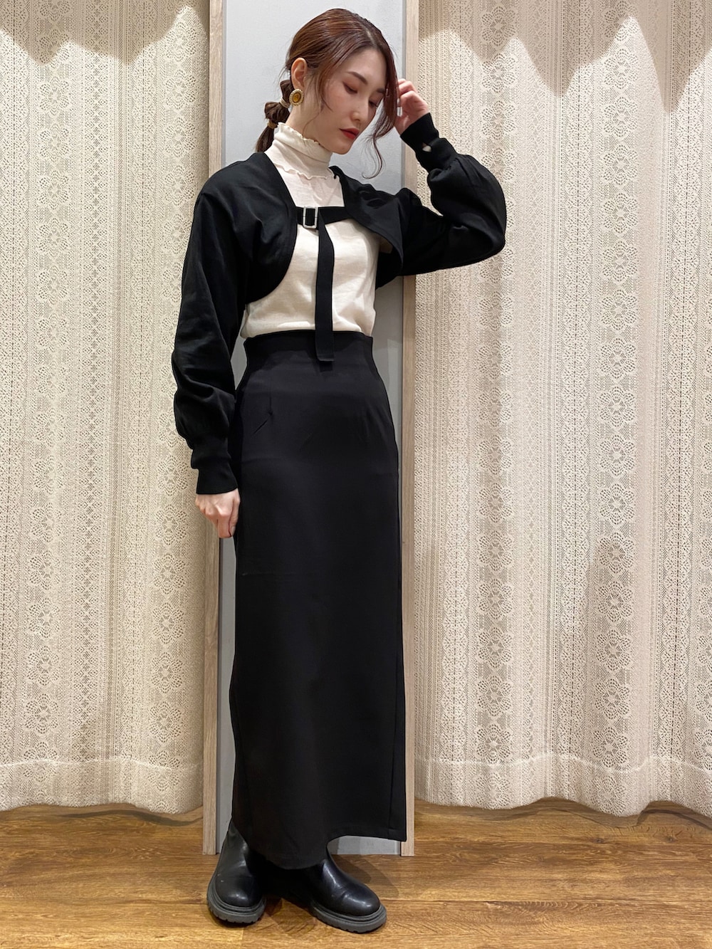 ブラック系のワンピース、ホワイト系のTシャツ/カットソー、ブラック系のスカートを着用したレディースの冬コーディネートの2枚目の写真