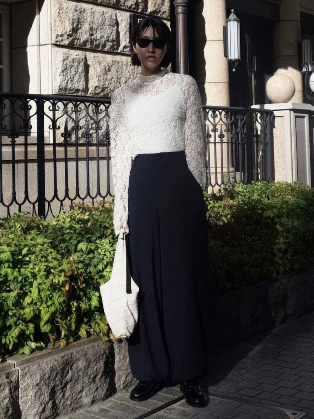 ホワイト系のTシャツ/カットソー、ブルー系のカーゴパンツ、ホワイト系のハンドバッグを着用したレディースの秋コーディネートの2枚目の写真