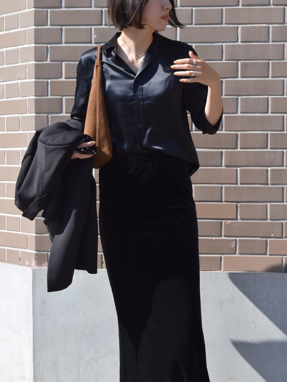 ブラック系のシャツ/ブラウス、イエロー系のハンドバッグ、ブラック系のスニーカーを着用したレディースの秋コーディネートの5枚目の写真