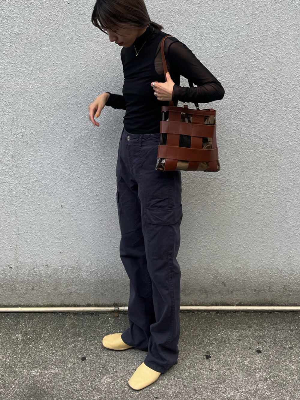 ブラック系のトップス、ブラック系のカーゴパンツ、イエロー系のシューズを着用したレディースの秋コーディネートの2枚目の写真