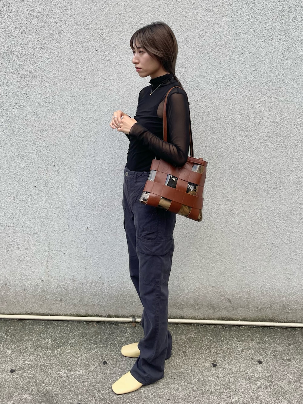 ブラック系のトップス、ブラック系のカーゴパンツ、イエロー系のシューズを着用したレディースの秋コーディネートの3枚目の写真