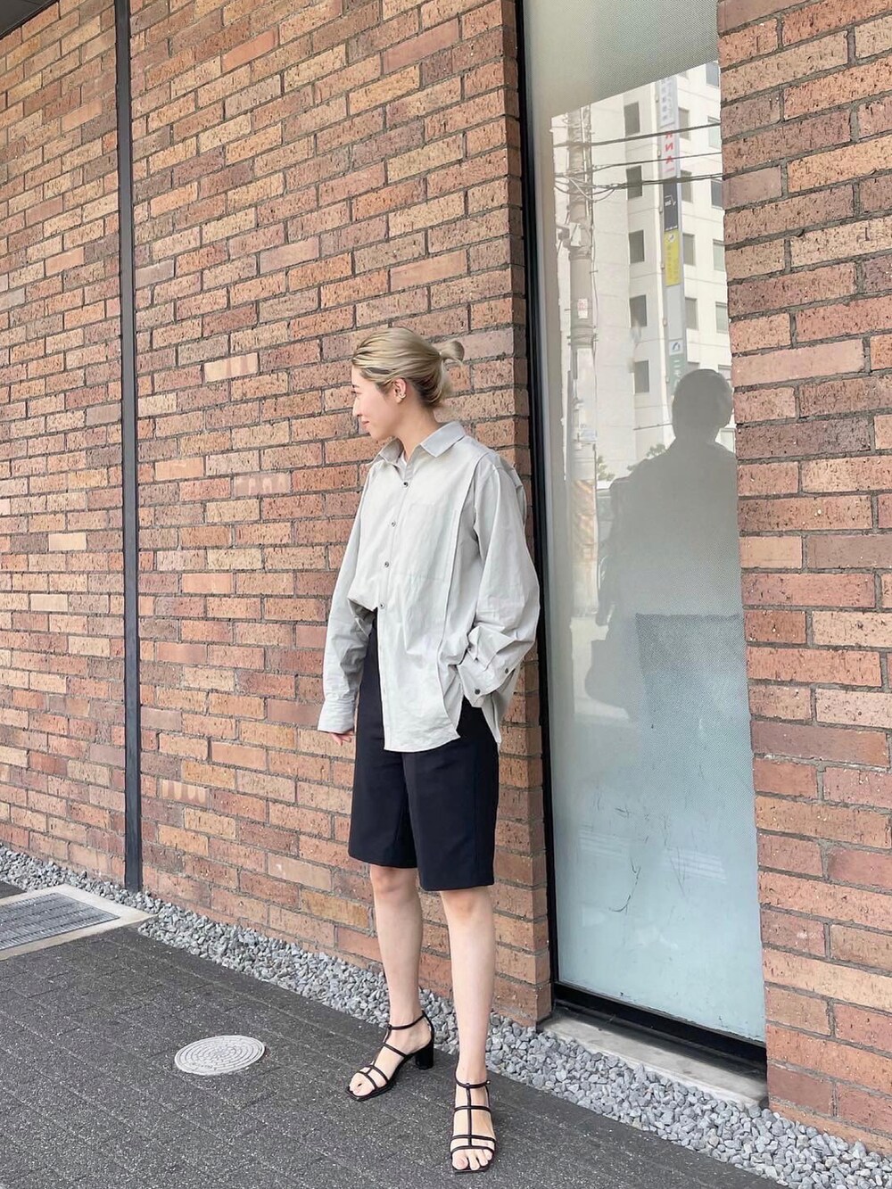 ピンク系のショルダーバッグ、ブラック系のサンダル、ホワイト系のシャツ/ブラウスを着用したレディースの春コーディネートの3枚目の写真