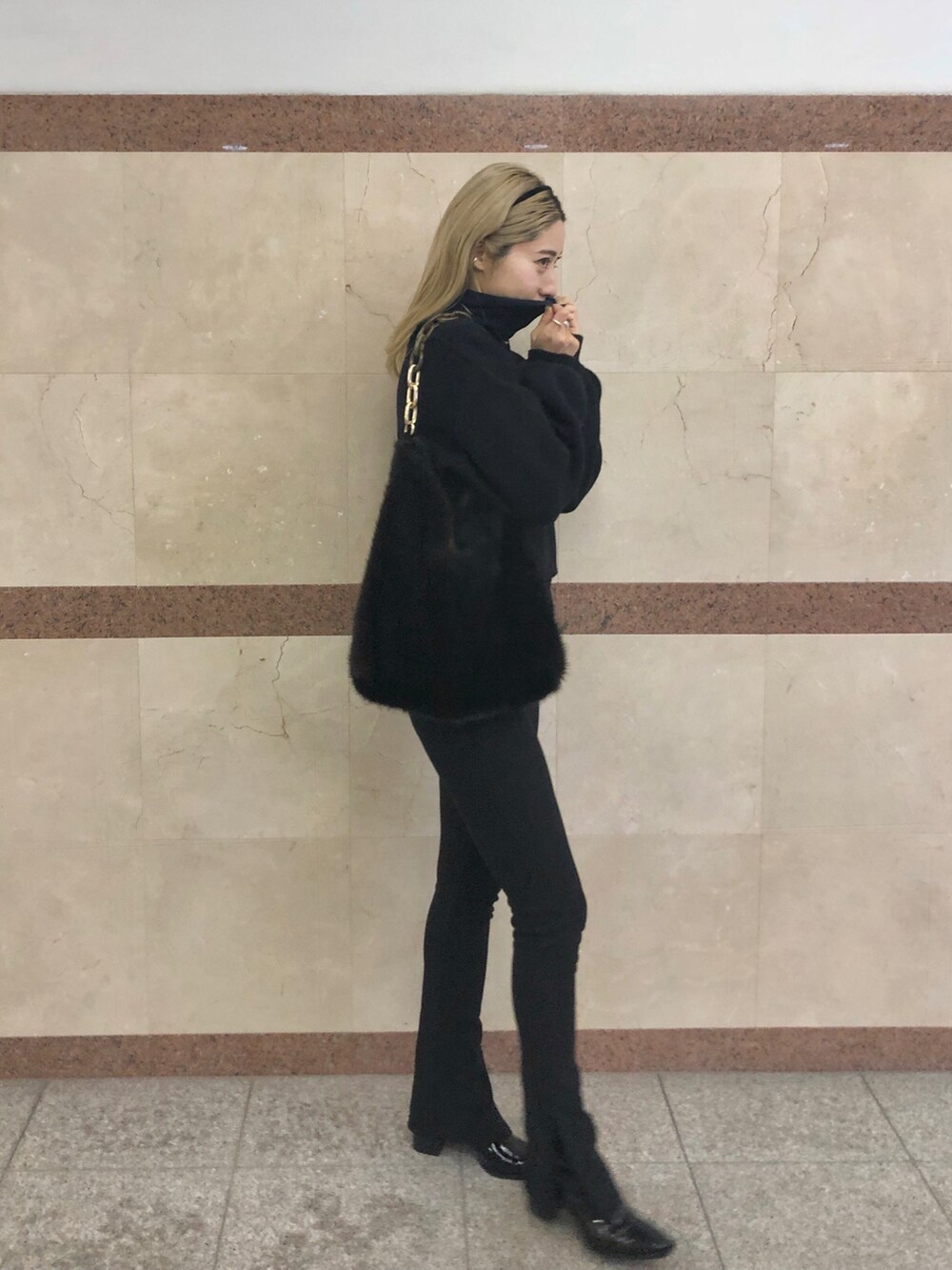 ブラウン系のトートバッグ、ブラック系のニット/セーター、ブラック系のニット/セーターを着用したレディースの冬コーディネートの2枚目の写真