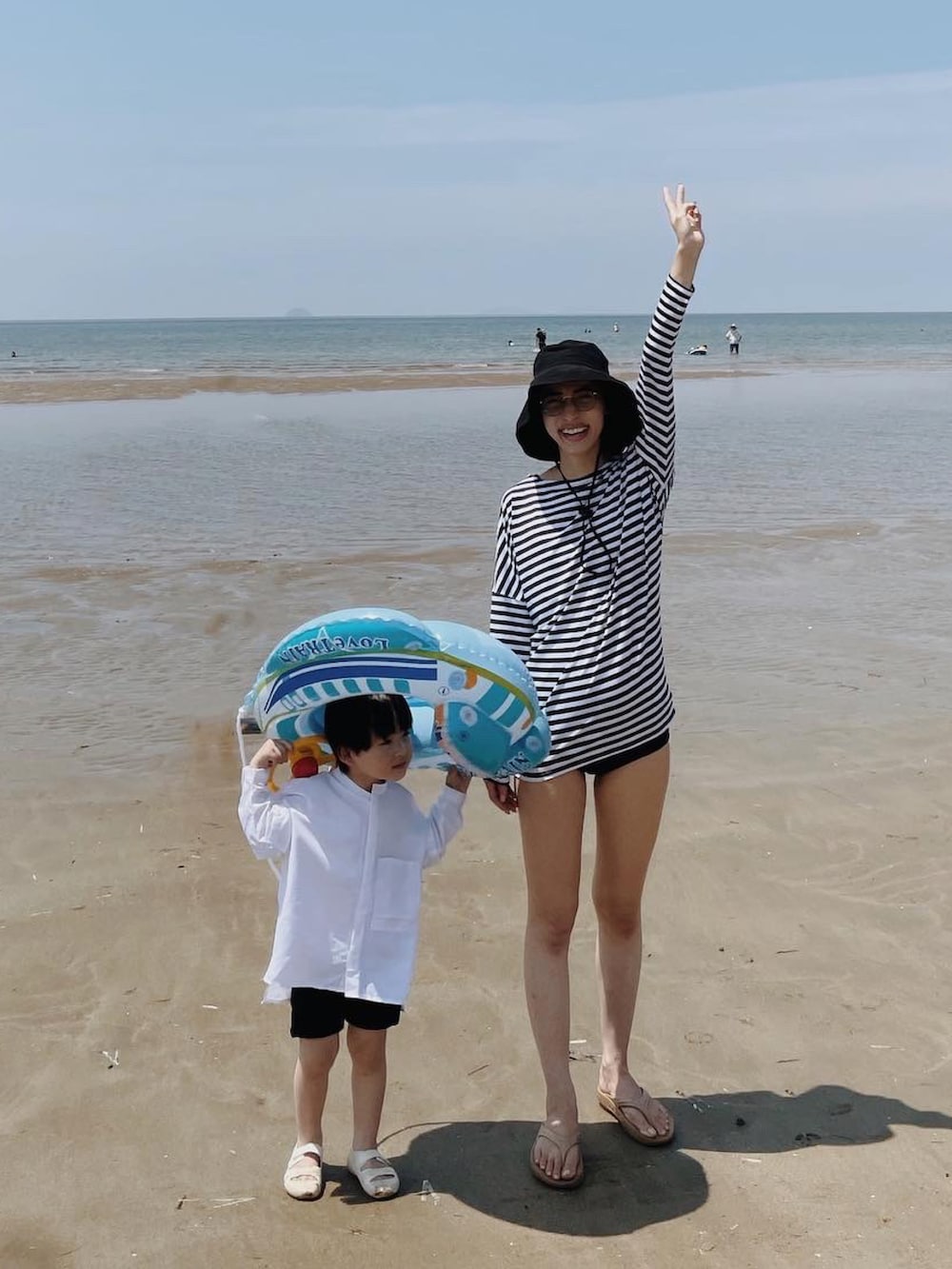 ベージュ系のサンダル、ブラック系のハットを着用したレディースの夏コーディネートの2枚目の写真