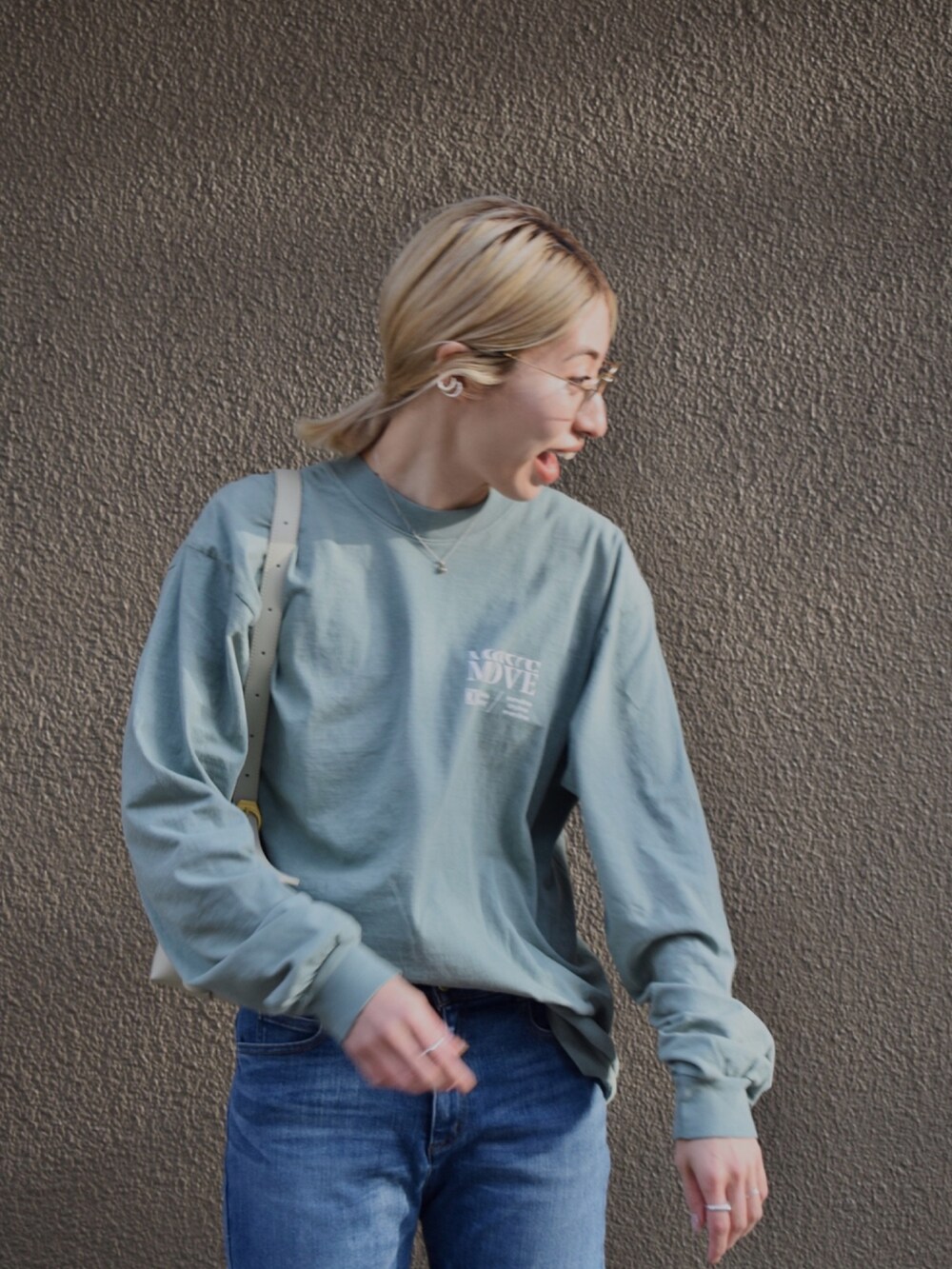 グリーン系のTシャツ/カットソー、ブルー系のデニムパンツ、ベージュ系のブーツを着用したレディースの春コーディネートの3枚目の写真