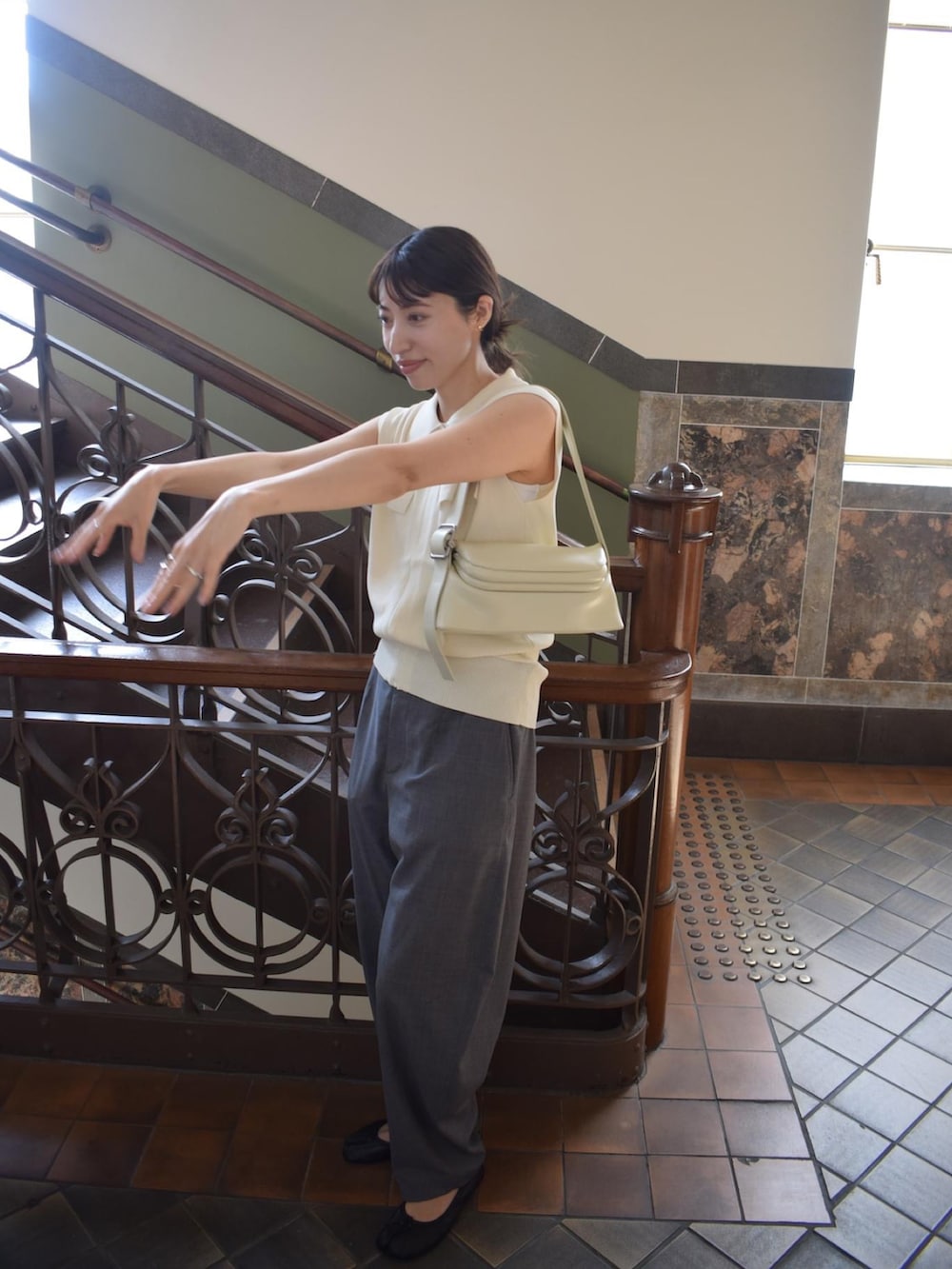 ベージュ系のショルダーバッグ、グレー系のその他パンツ、ブラック系のパンプスを着用したレディースの夏コーディネートの2枚目の写真