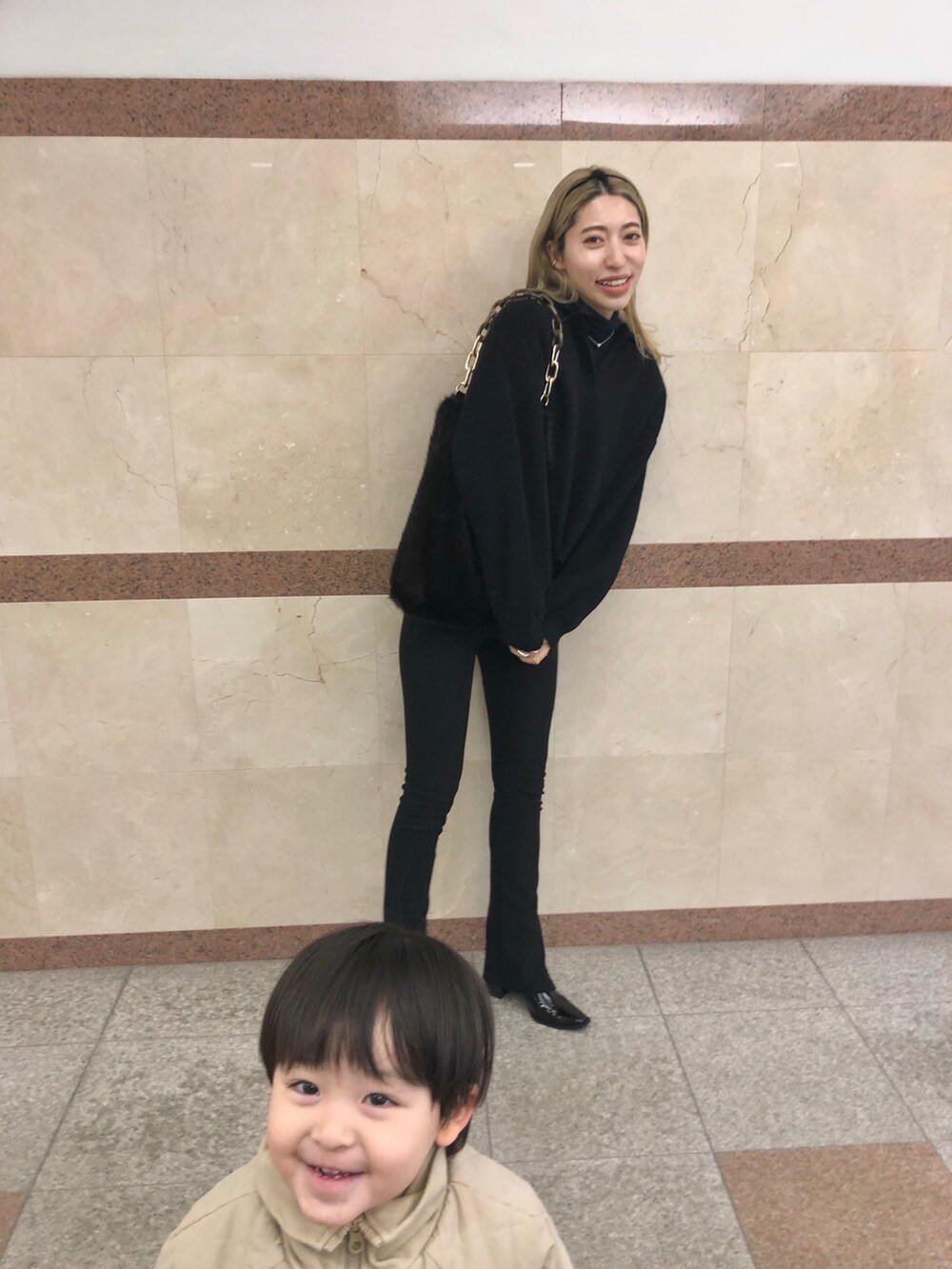 ブラウン系のトートバッグ、ブラック系のニット/セーター、ブラック系のニット/セーターを着用したレディースの冬コーディネートの3枚目の写真