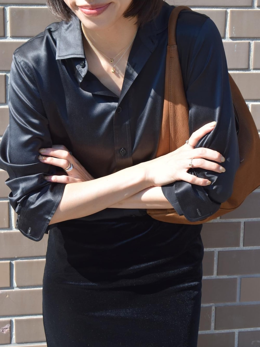 ブラック系のシャツ/ブラウス、イエロー系のハンドバッグ、ブラック系のスニーカーを着用したレディースの秋コーディネートの3枚目の写真