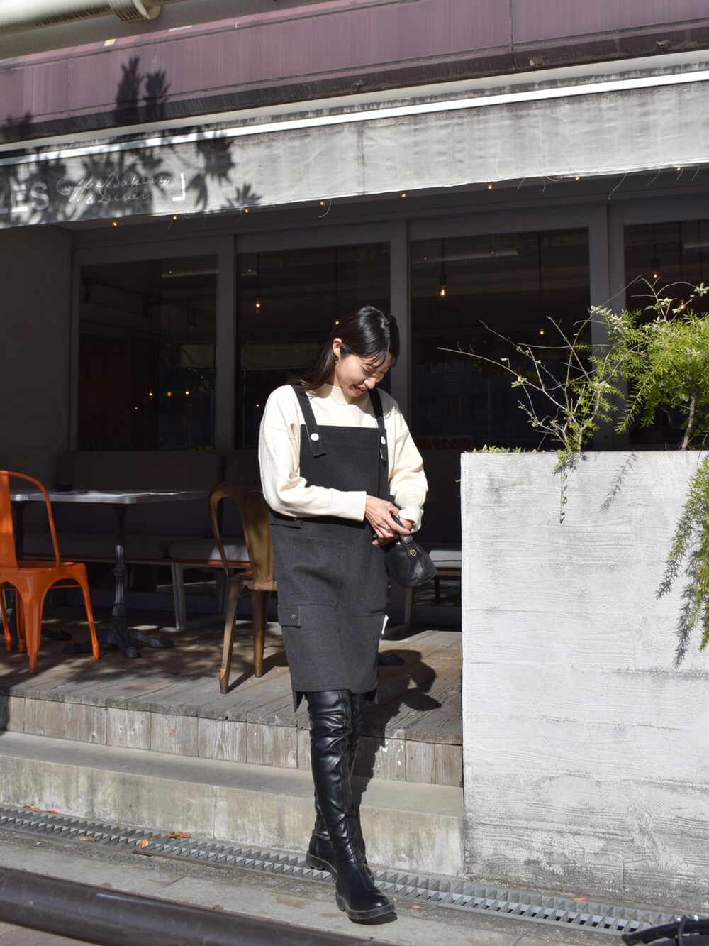 グレー系のワンピース/ドレス、ホワイト系のニット/セーター、ブラック系のブーツを着用したレディースの冬コーディネートの5枚目の写真