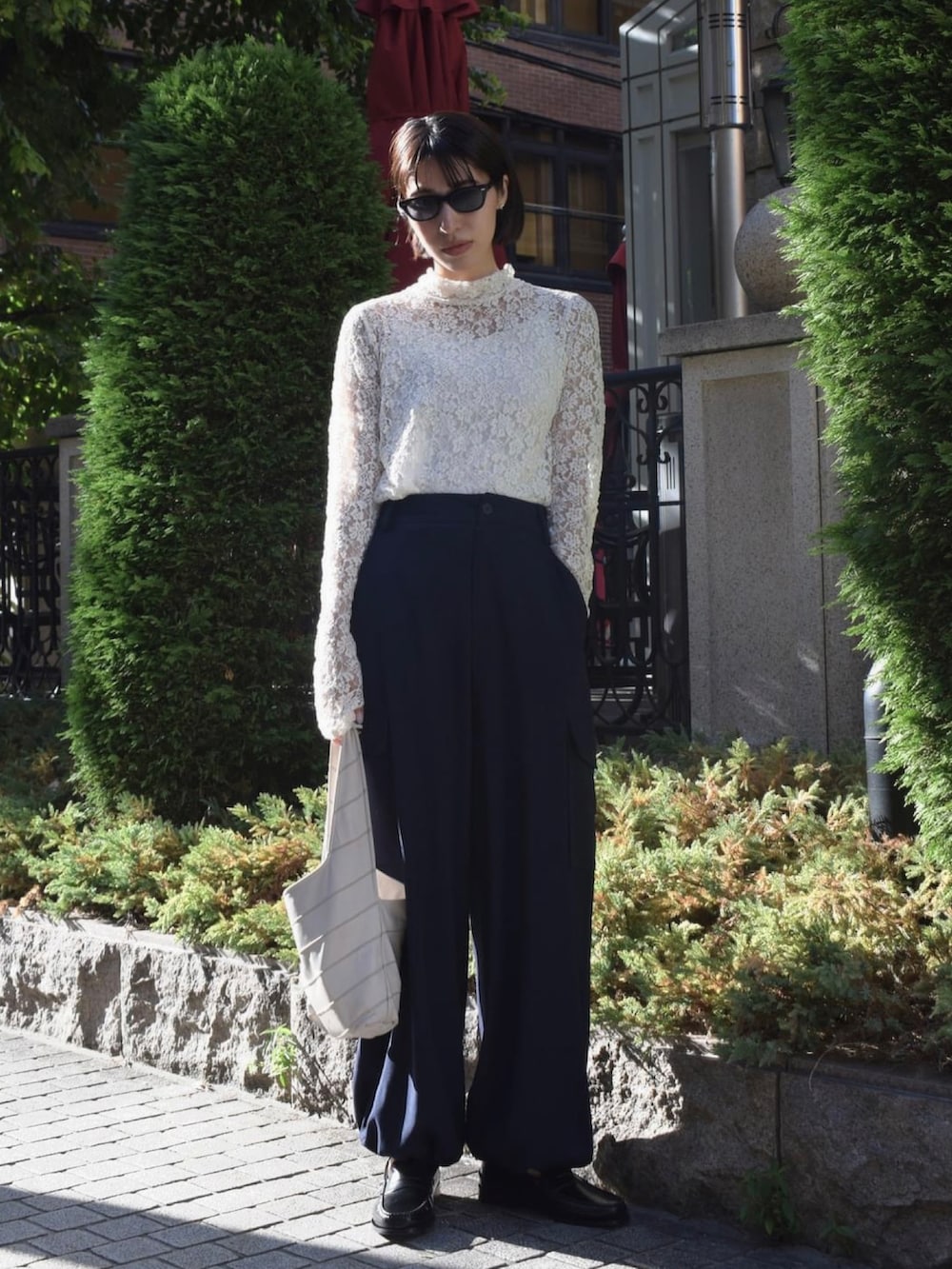 ホワイト系のTシャツ/カットソー、ブルー系のカーゴパンツ、ホワイト系のハンドバッグを着用したレディースの秋コーディネートの3枚目の写真