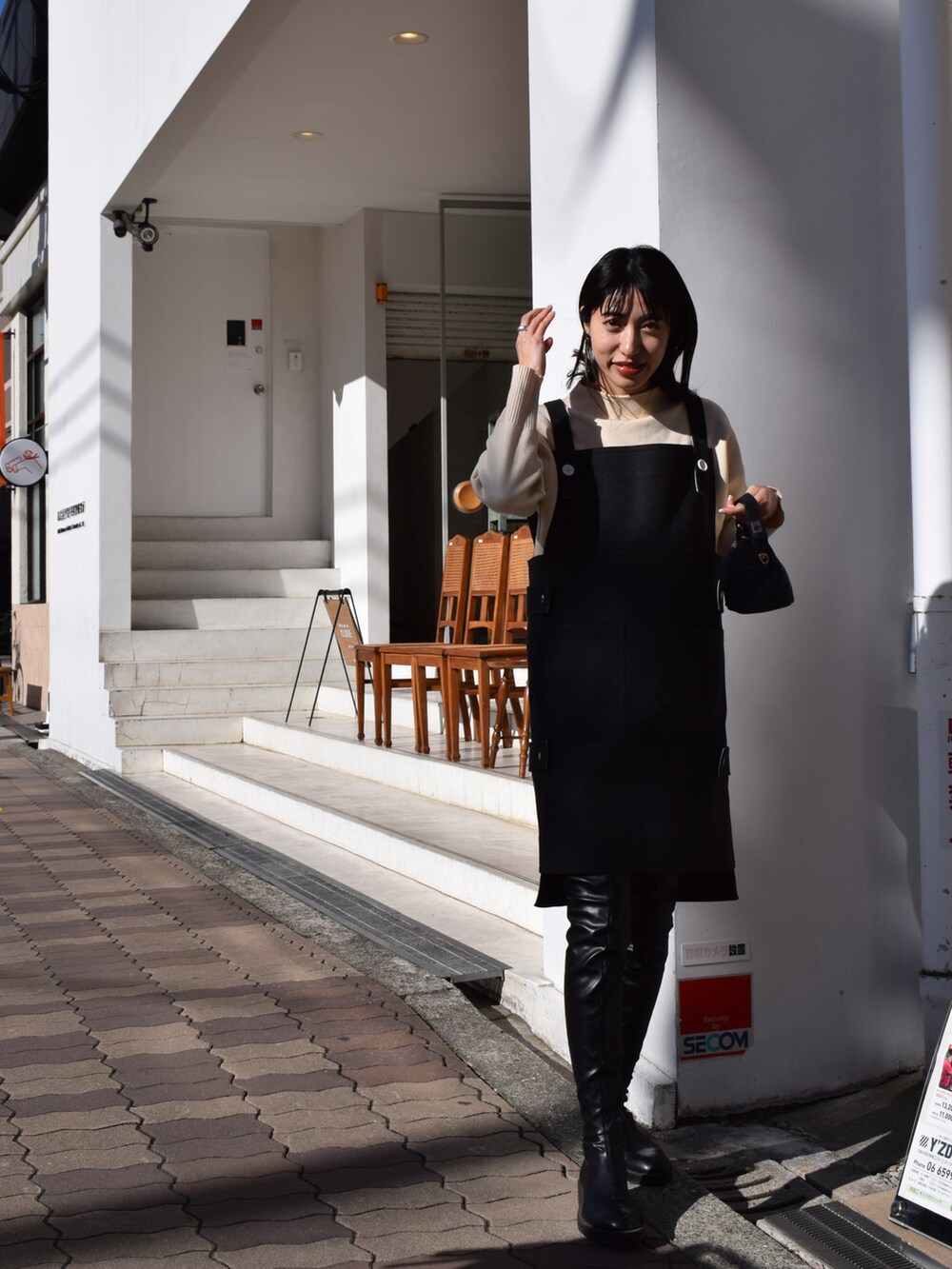 グレー系のワンピース/ドレス、ホワイト系のニット/セーター、ブラック系のブーツを着用したレディースの冬コーディネートの4枚目の写真