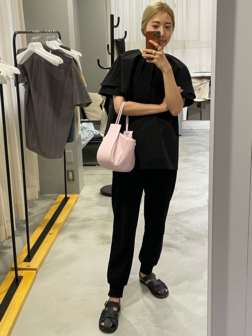 ピンク系のショルダーバッグ、ブラック系のシャツ/ブラウス、ブラック系のシューズを着用したレディースの夏コーディネートの2枚目の写真
