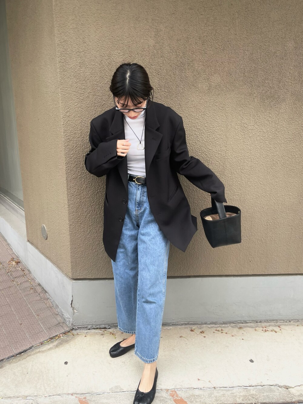 ブラック系のテーラードジャケット、ブラック系のバッグ、ブラック系のパンプスを着用したレディースの春コーディネートの2枚目の写真