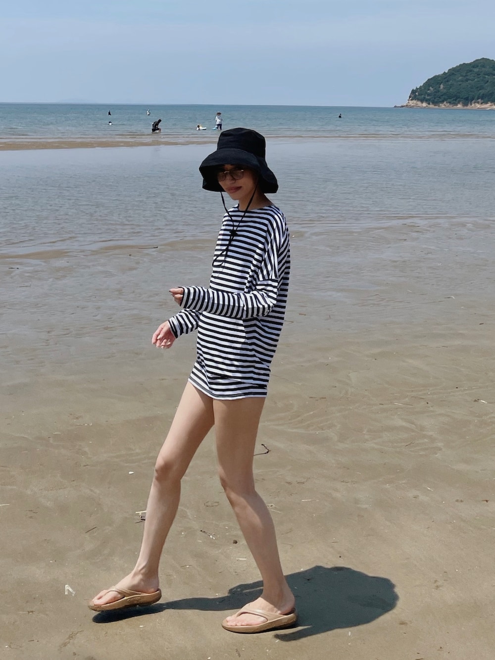 ベージュ系のサンダル、ブラック系のハットを着用したレディースの夏コーディネートの3枚目の写真