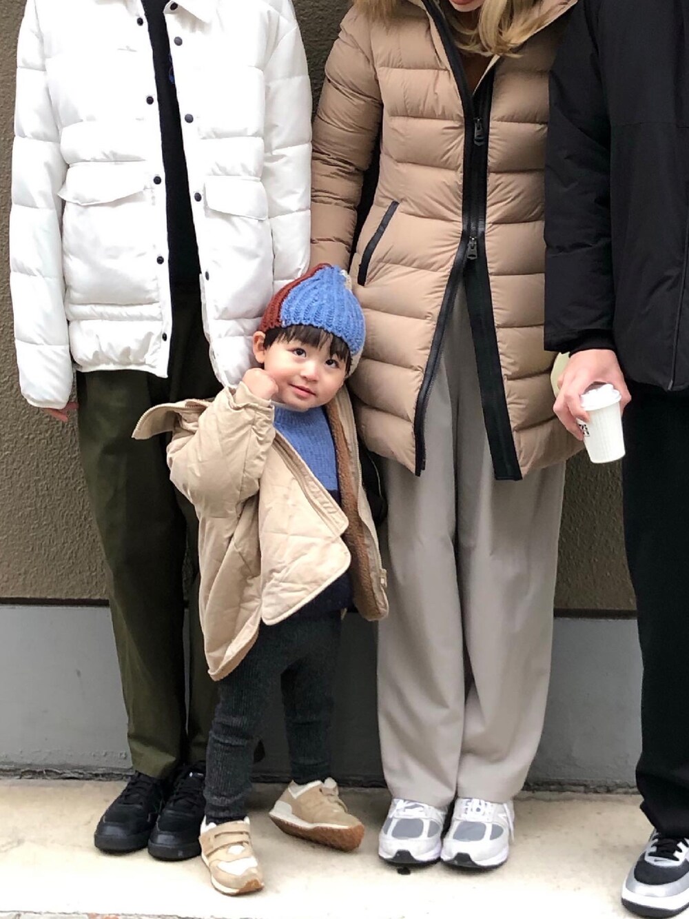 ベージュ系のダウンジャケット/コート、ホワイト系のハンドバッグ、グレー系のスラックスを着用したレディースの冬コーディネートの3枚目の写真