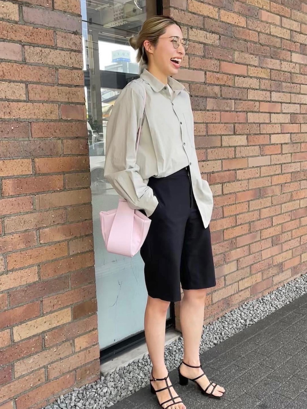 ピンク系のショルダーバッグ、ブラック系のサンダル、ホワイト系のシャツ/ブラウスを着用したレディースの春コーディネートの2枚目の写真