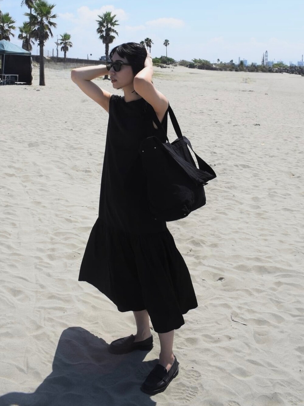 ブラック系のワンピース、ブラック系のトートバッグ、ブラック系のドレスシューズを着用したレディースの夏コーディネートの2枚目の写真