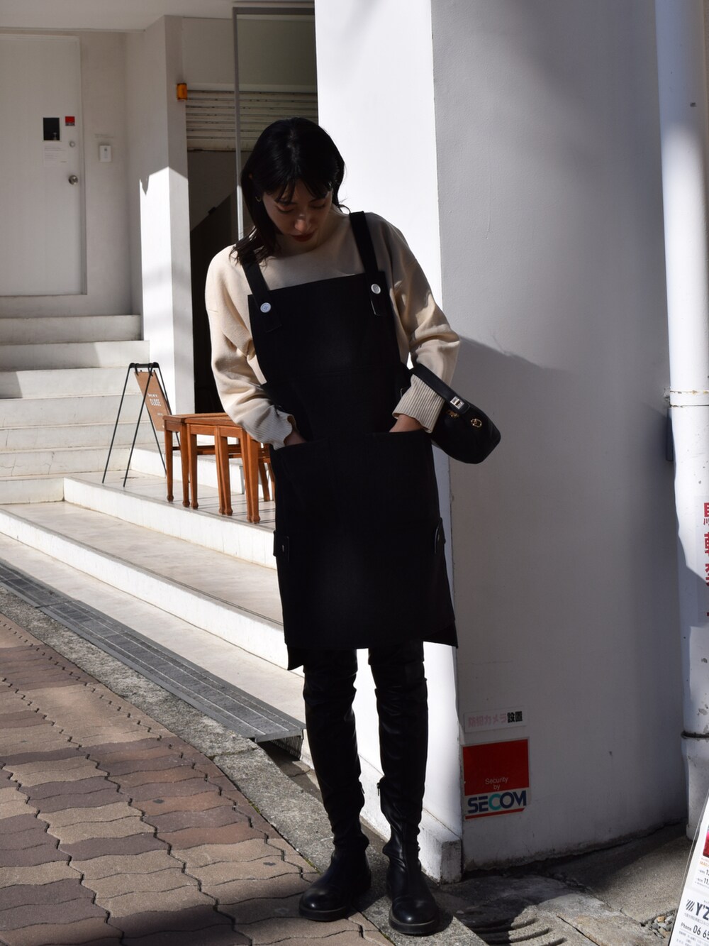 グレー系のワンピース/ドレス、ホワイト系のニット/セーター、ブラック系のブーツを着用したレディースの冬コーディネートの3枚目の写真