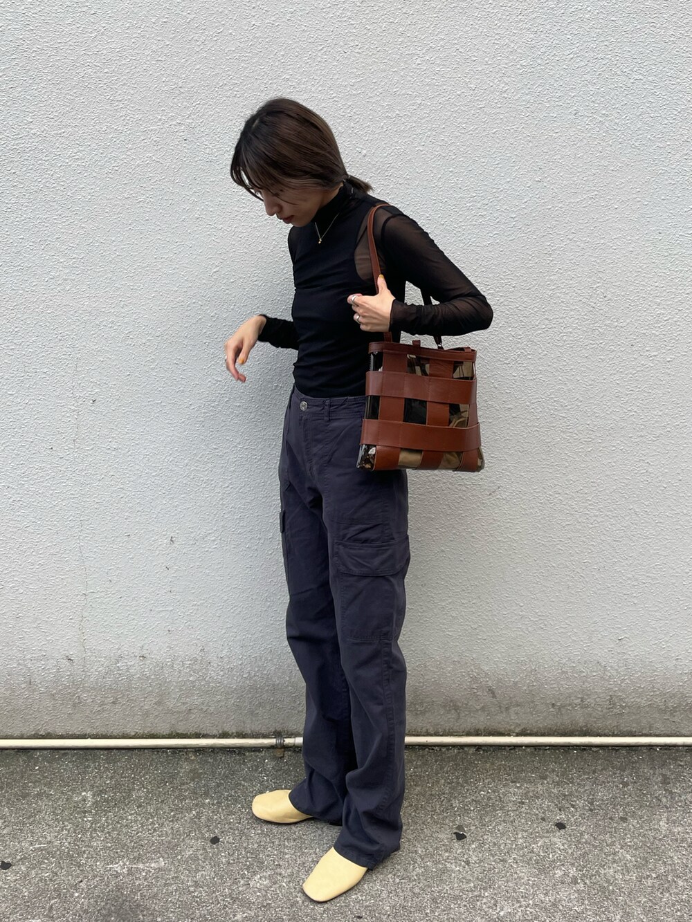 ブラック系のトップス、ブラック系のカーゴパンツ、イエロー系のシューズを着用したレディースの秋コーディネートの4枚目の写真