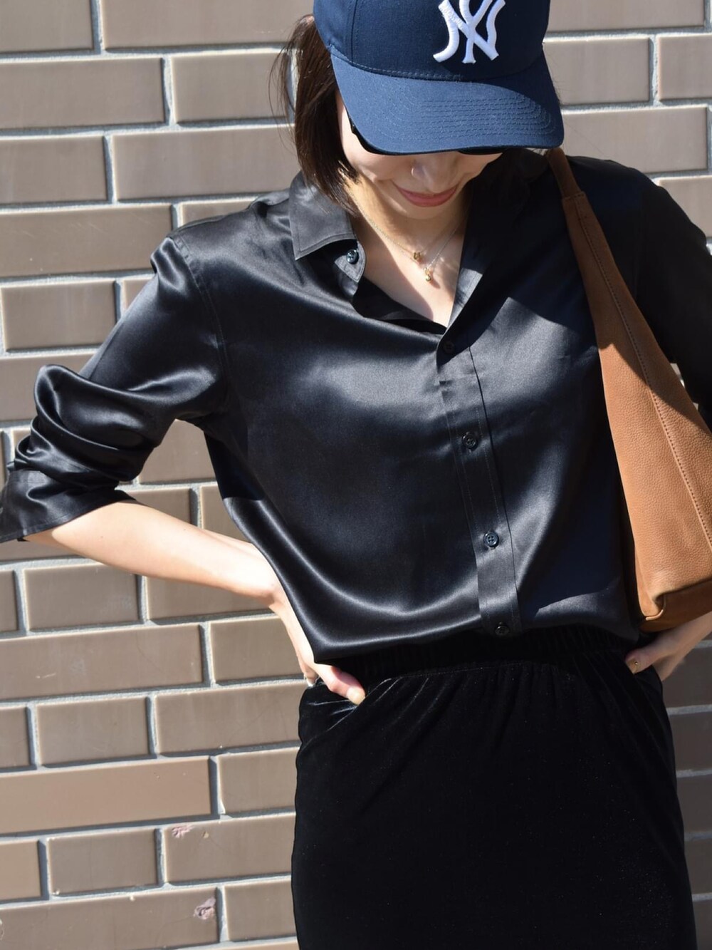 ブラック系のシャツ/ブラウス、イエロー系のハンドバッグ、ブラック系のスニーカーを着用したレディースの秋コーディネートの4枚目の写真