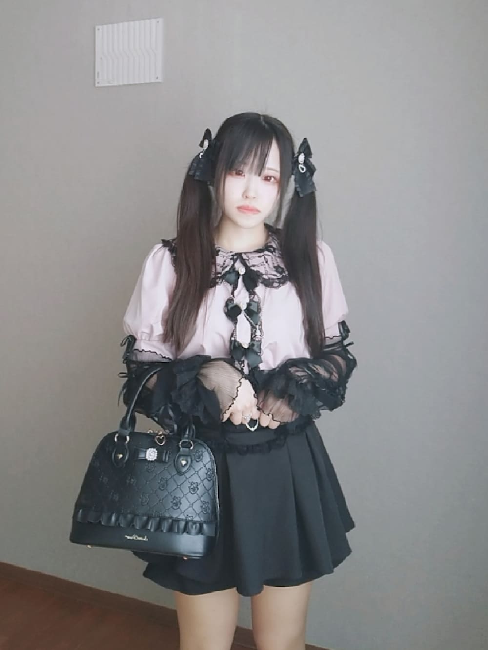 ピンク系のシャツ/ブラウス、ブラック系のスカート、ブラック系のボストンバッグを着用したレディースの秋コーディネートの2枚目の写真