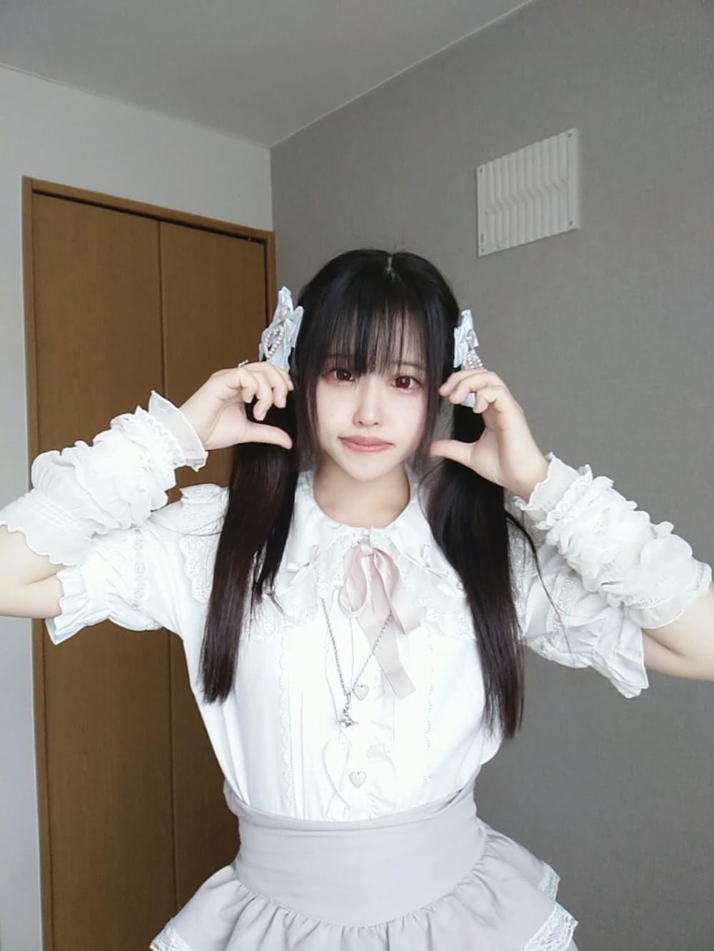 ホワイト系のシャツ/ブラウス、ピンク系のスカート、ホワイト系のハンドバッグを着用したレディースの秋コーディネートの2枚目の写真