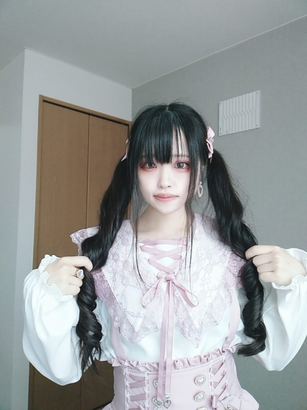 ピンク系のスカート、ホワイト系のシャツ/ブラウス、ピンク系のハンドバッグを着用したレディースの秋コーディネートの2枚目の写真