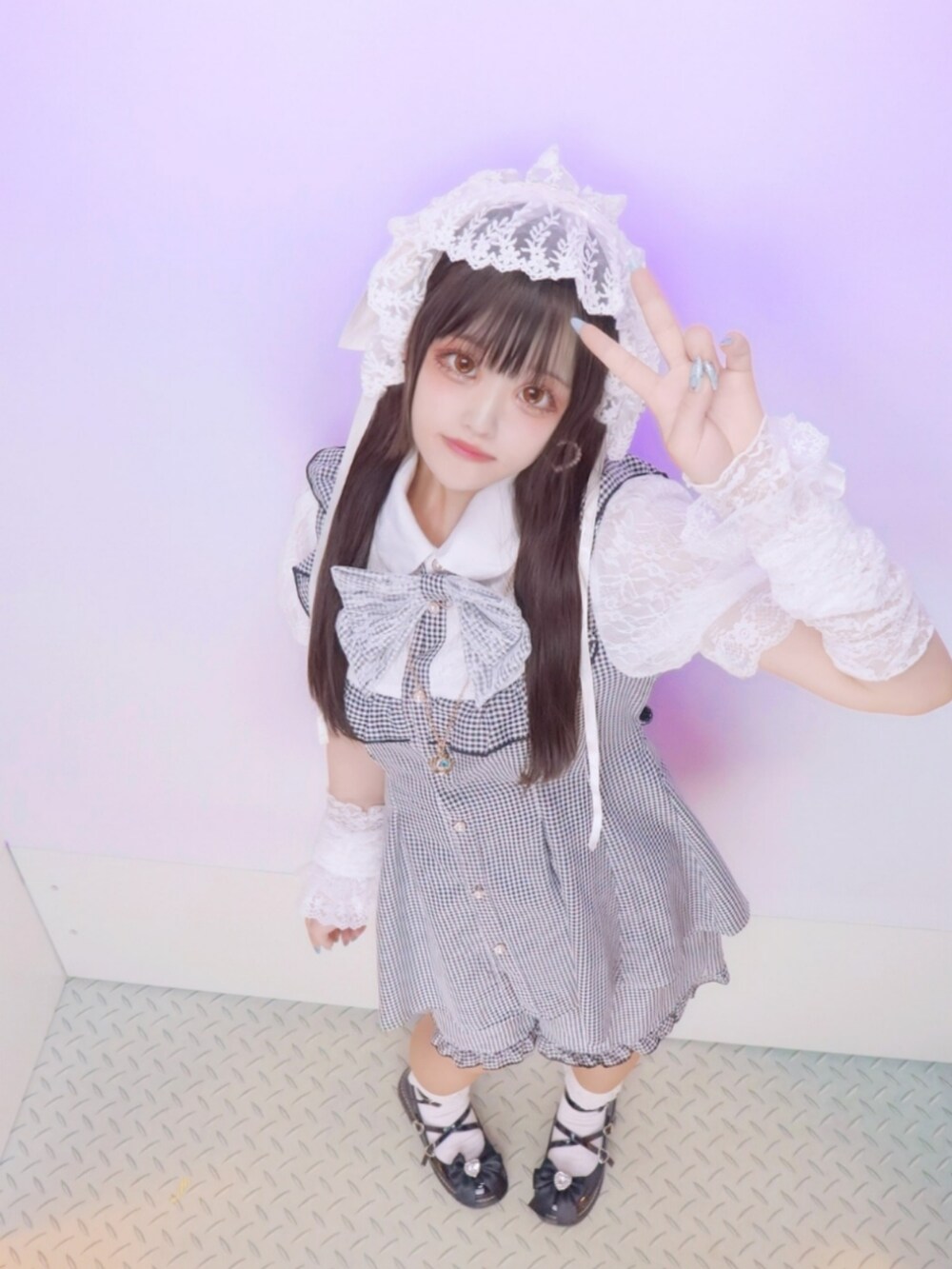 ブラック系のチュニック、ブラック系のパンプス、ホワイト系のアームカバーを着用したレディースの夏コーディネートの2枚目の写真