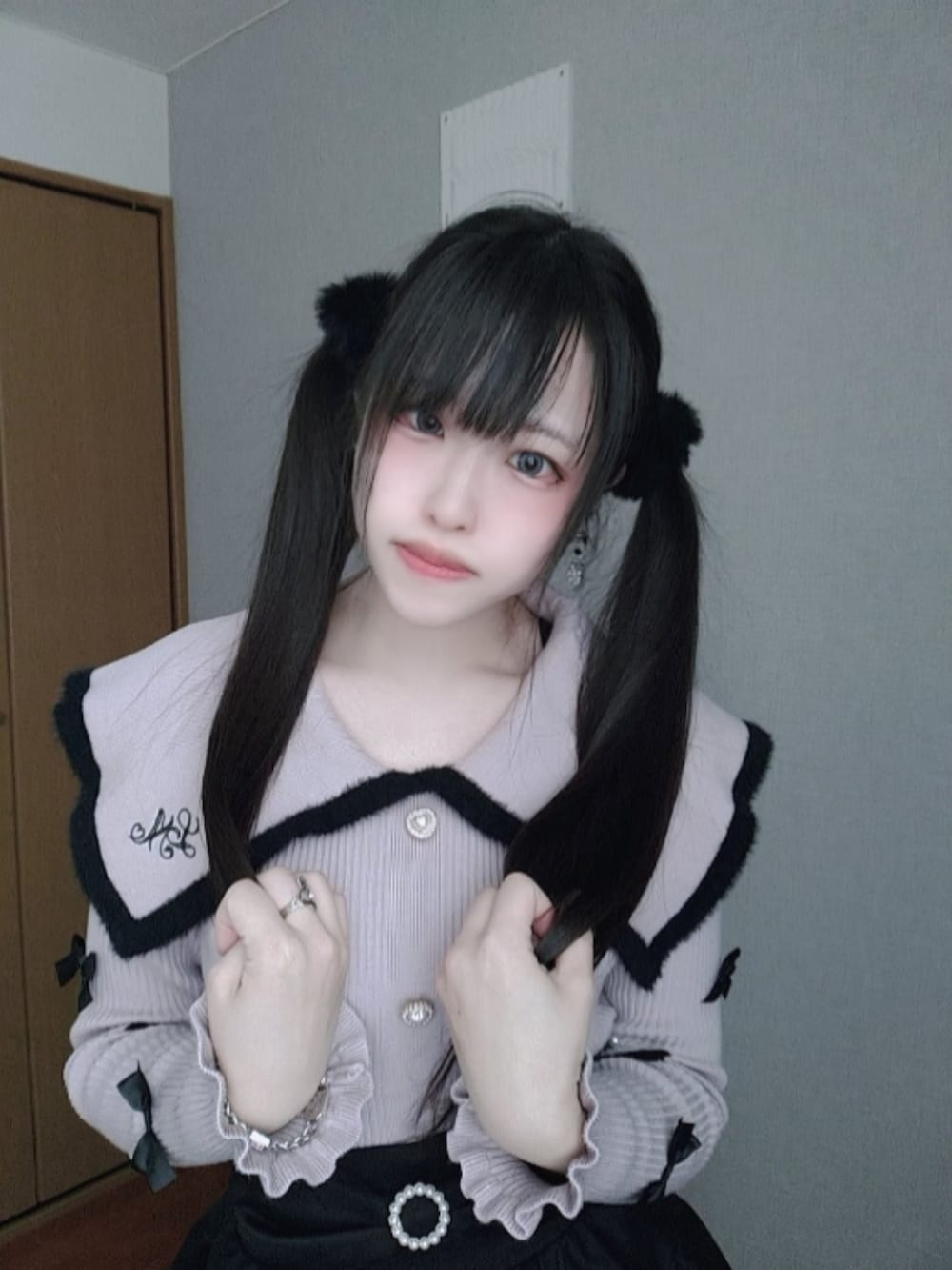 ブラック系のスカート、ピンク系のニット/セーター、ブラック系のレッグウォーマーを着用したレディースの春コーディネートの2枚目の写真