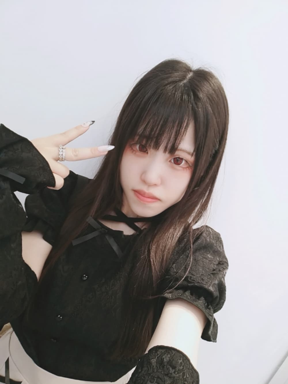 ブラック系のシャツ/ブラウス、ピンク系のスカート、ブラック系のパンプスを着用したレディースの秋コーディネートの2枚目の写真