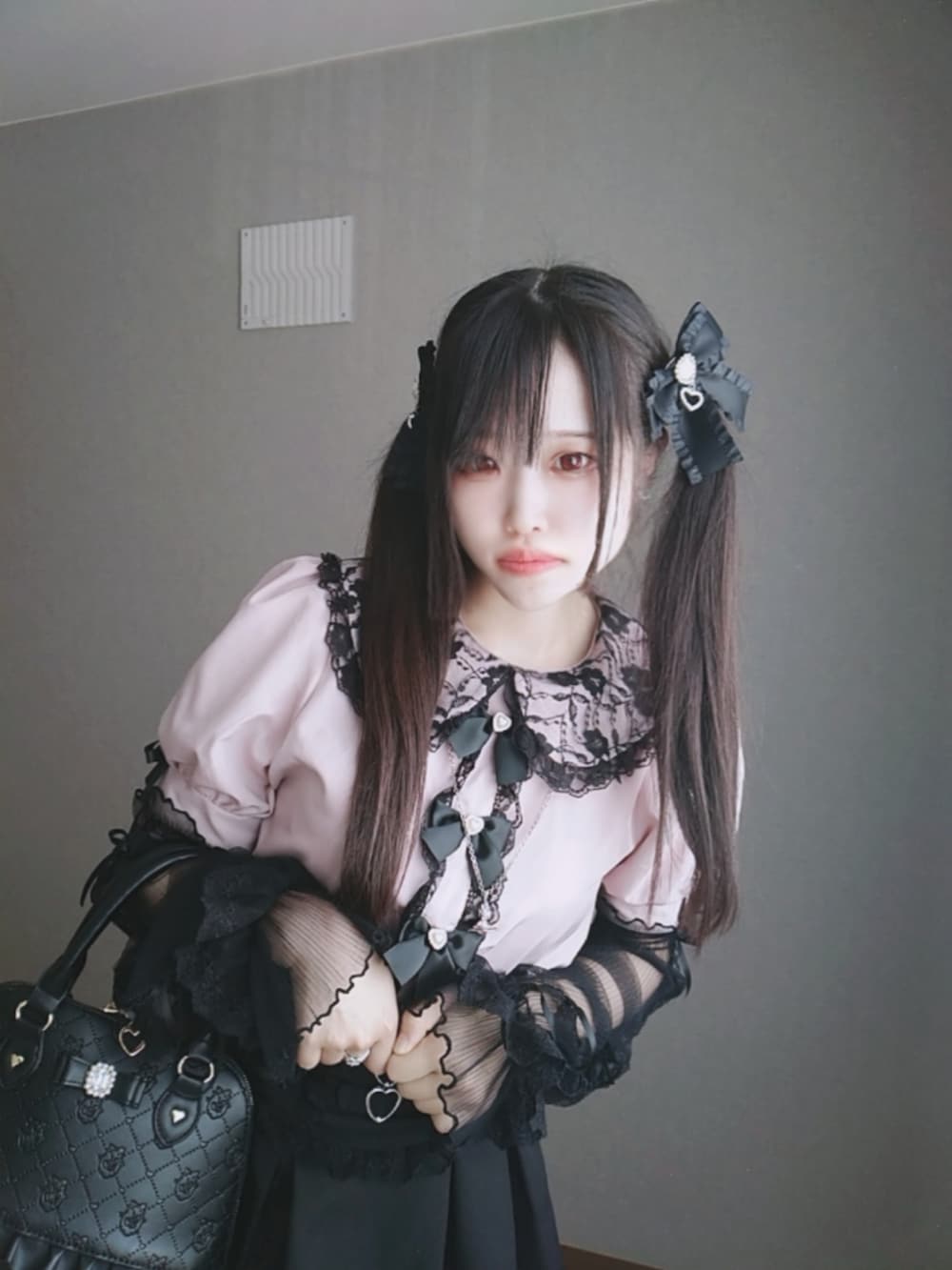 ピンク系のシャツ/ブラウス、ブラック系のスカート、ブラック系のボストンバッグを着用したレディースの秋コーディネートの3枚目の写真