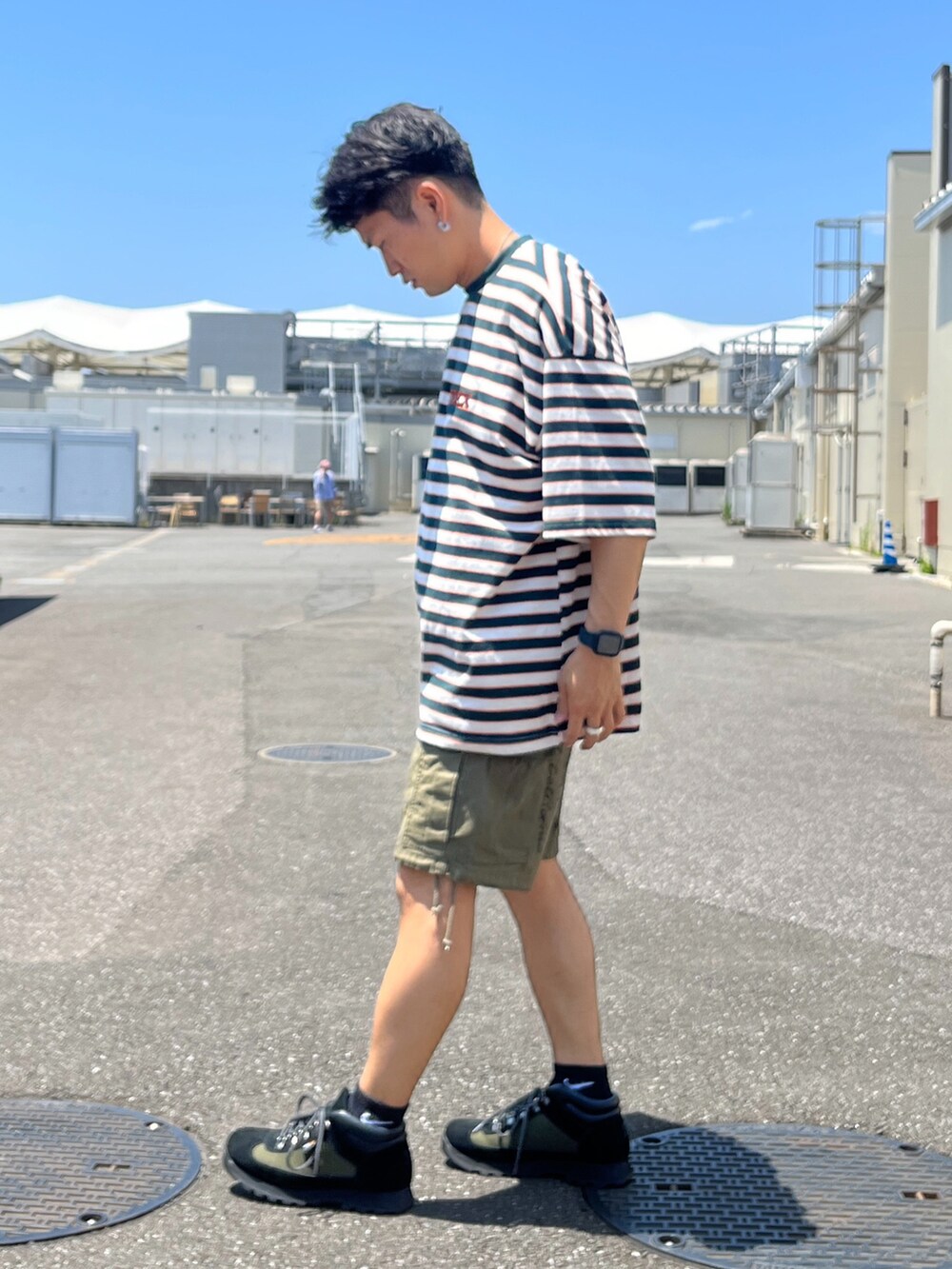 グリーン系のTシャツ/カットソー、グリーン系のカーゴパンツ、ブラック系のブーツを着用したメンズの夏コーディネートの2枚目の写真