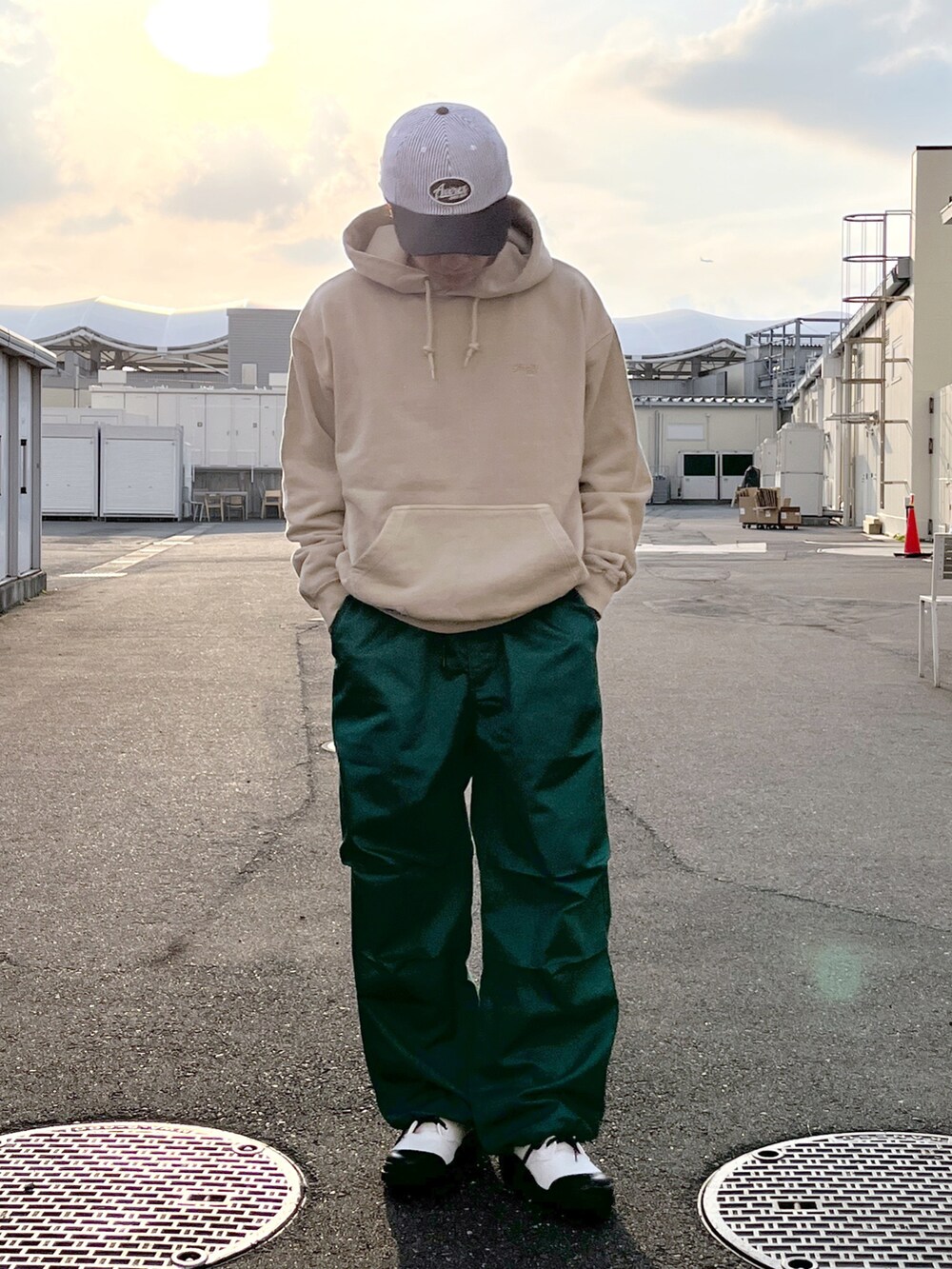 ベージュ系のパーカー、グリーン系のその他パンツ、ホワイト系のブーツを着用したメンズの春コーディネートの3枚目の写真