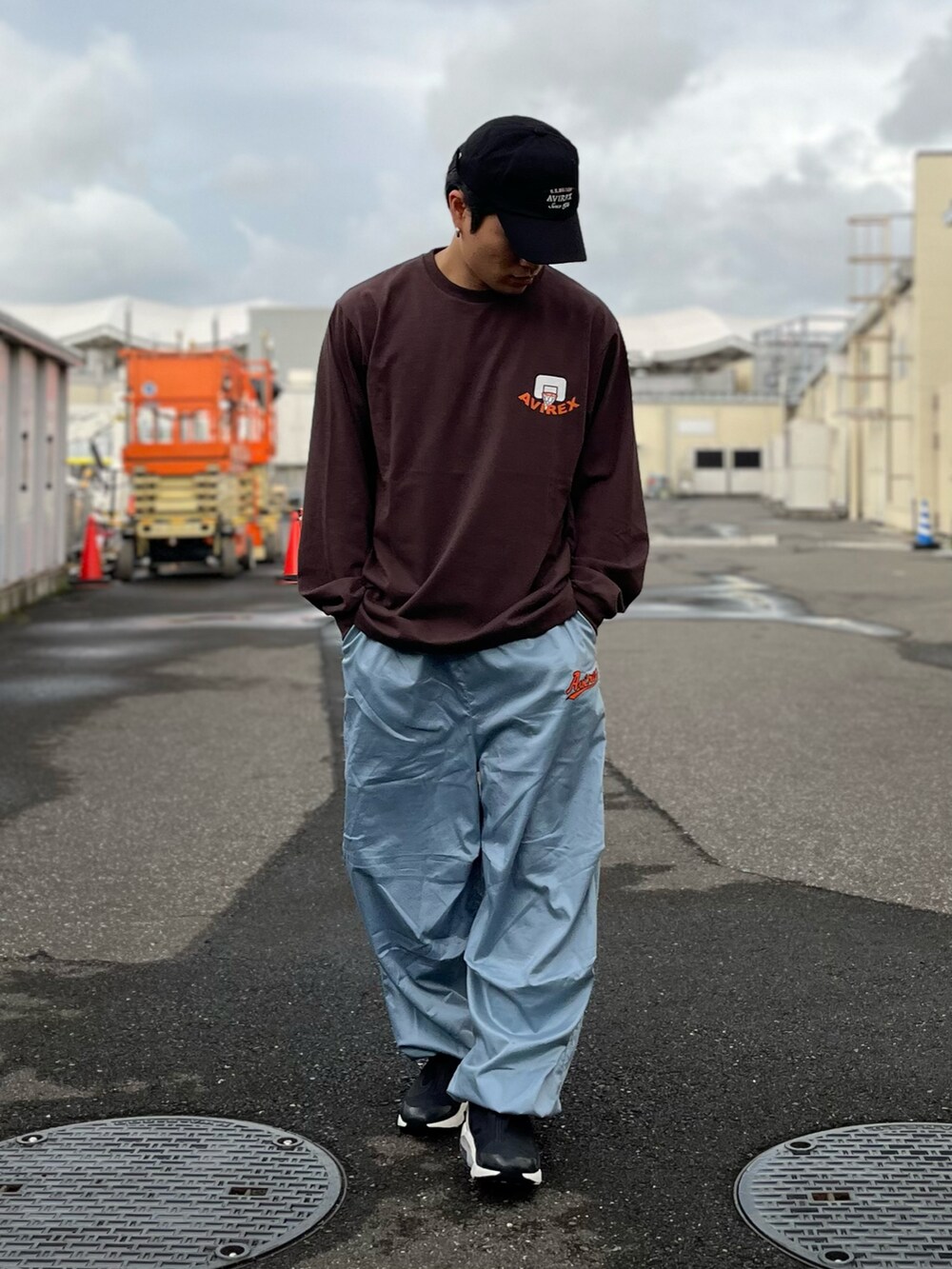 ブラウン系のTシャツ/カットソー、ブルー系のパンツ、ブラック系のキャップを着用したメンズの秋コーディネートの2枚目の写真