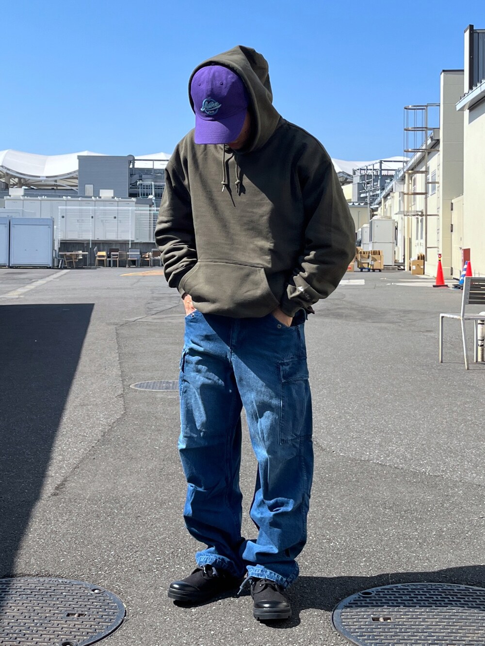 グリーン系のパーカー、ブラウン系のTシャツ/カットソー、ブルー系のデニムパンツを着用したメンズの春コーディネートの2枚目の写真