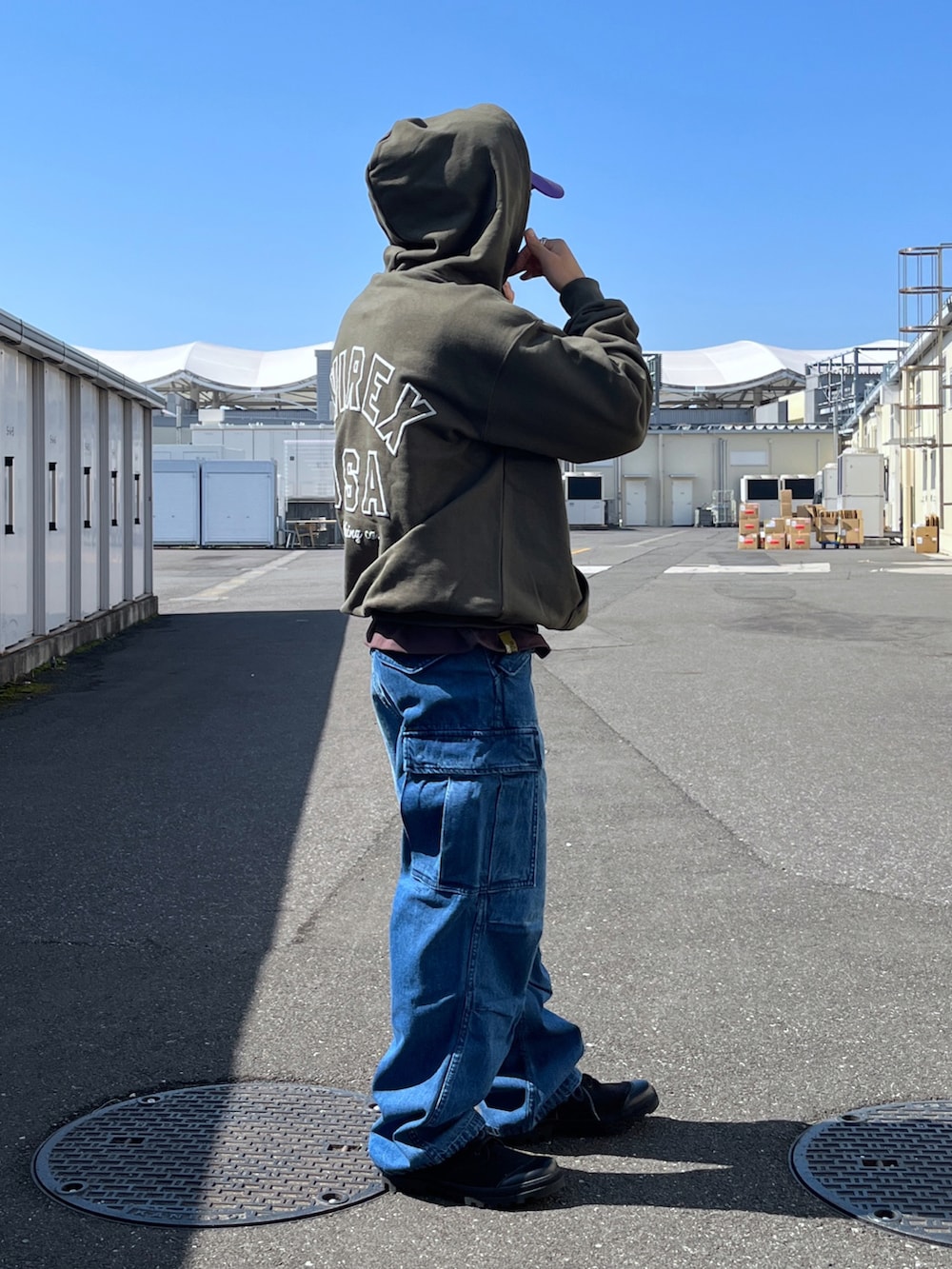 グリーン系のパーカー、ブラウン系のTシャツ/カットソー、ブルー系のデニムパンツを着用したメンズの春コーディネートの4枚目の写真