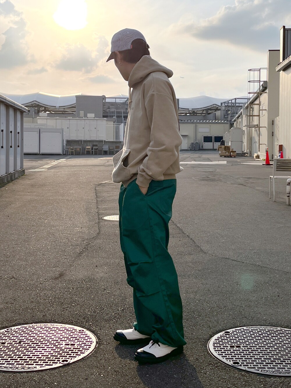 ベージュ系のパーカー、グリーン系のその他パンツ、ホワイト系のブーツを着用したメンズの春コーディネートの2枚目の写真