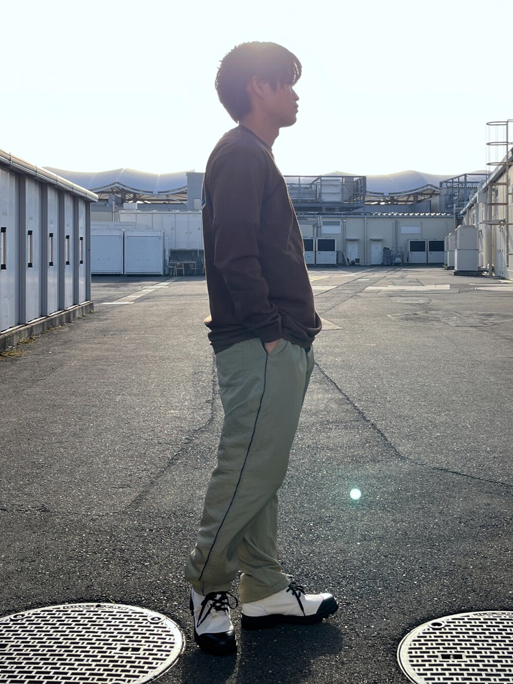 ブラウン系のTシャツ/カットソー、ベージュ系のその他パンツ、ホワイト系のブーツを着用したメンズの春コーディネートの3枚目の写真