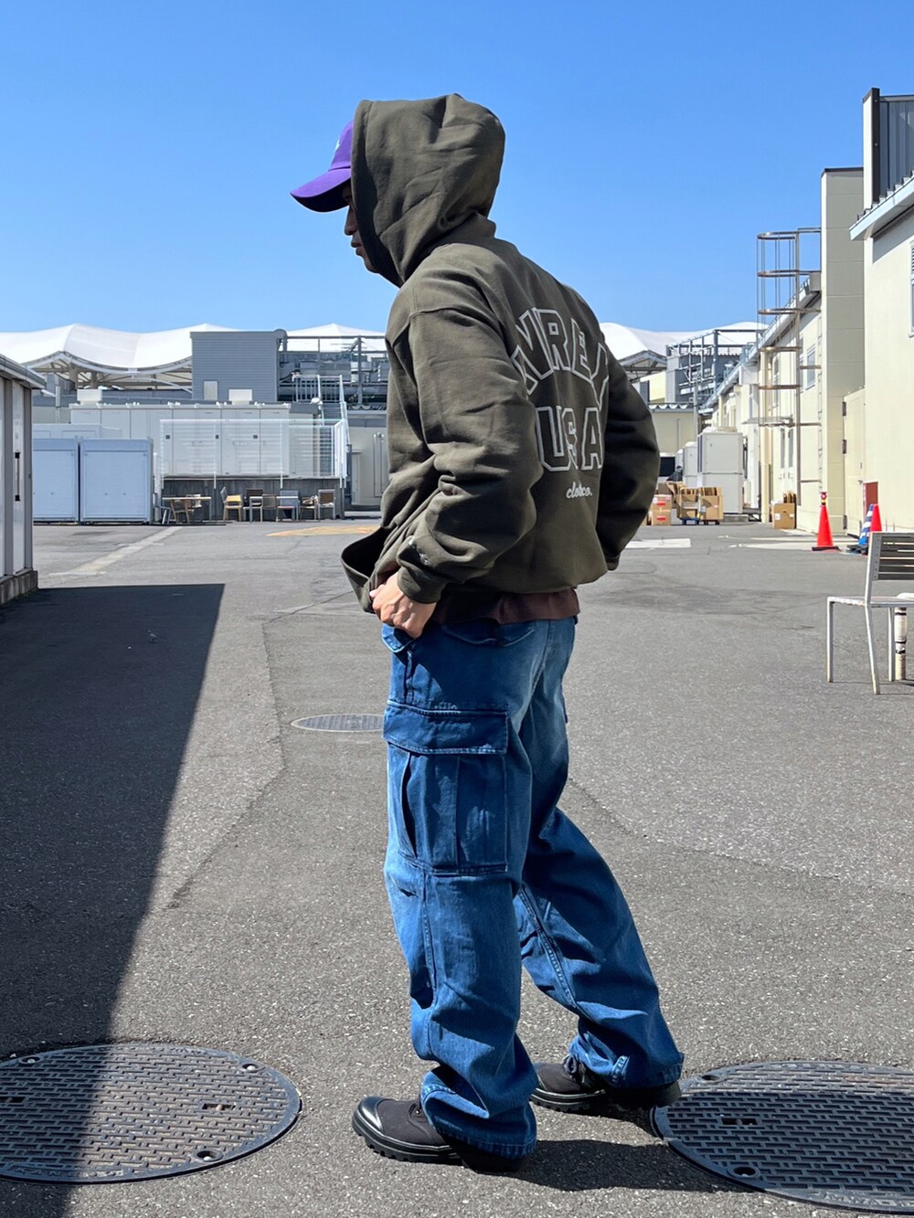 グリーン系のパーカー、ブラウン系のTシャツ/カットソー、ブルー系のデニムパンツを着用したメンズの春コーディネートの3枚目の写真