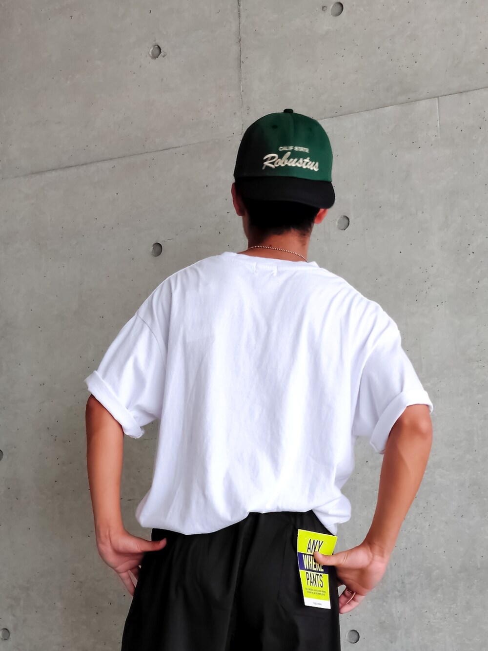 ホワイト系のTシャツ/カットソー、ブラック系のカーゴパンツ、グリーン系のキャップを着用したメンズの夏コーディネートの3枚目の写真