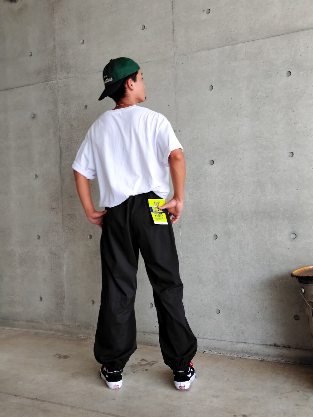 ホワイト系のTシャツ/カットソー、ブラック系のカーゴパンツ、グリーン系のキャップを着用したメンズの夏コーディネートの4枚目の写真