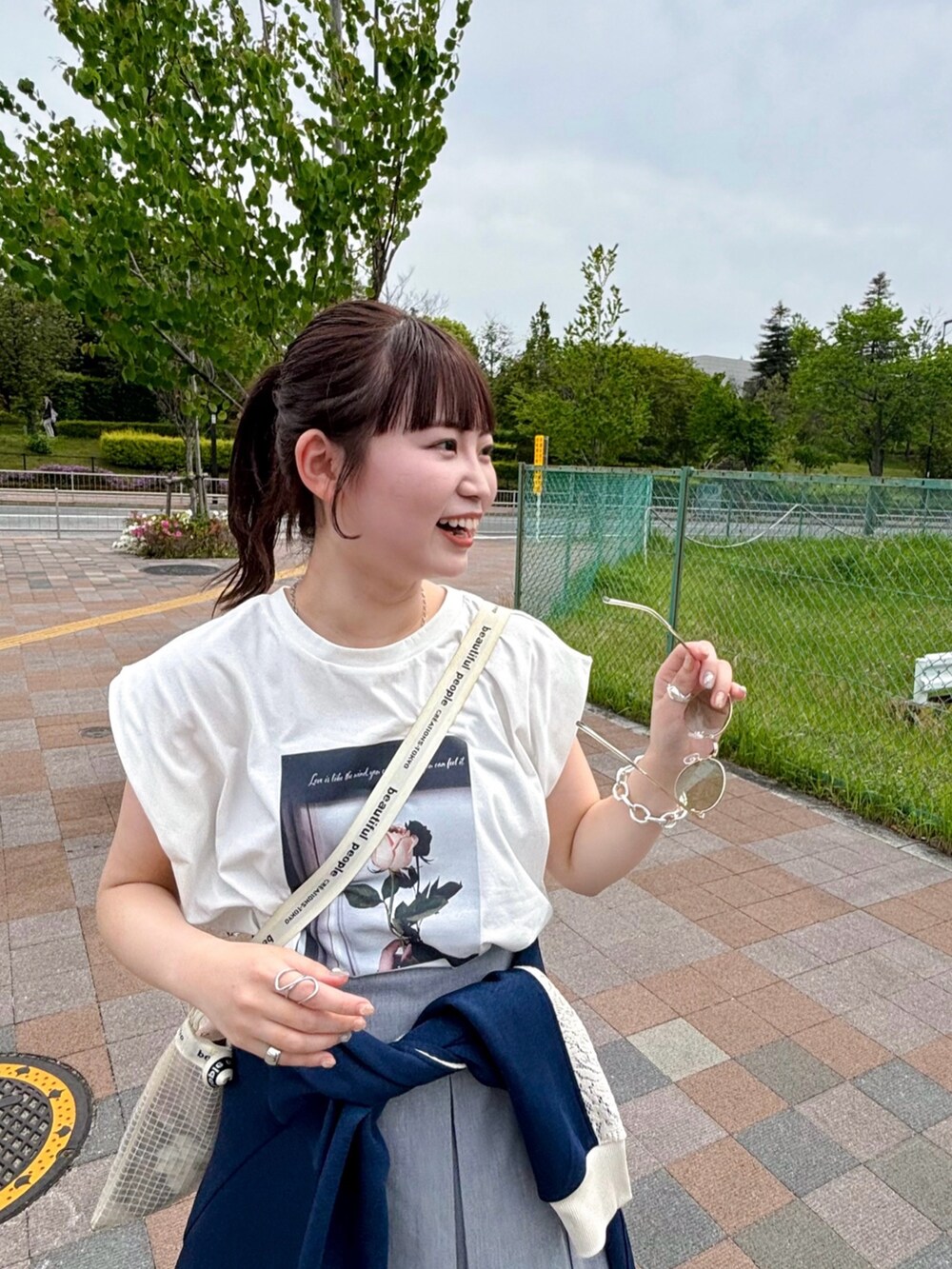 ブルー系のトップス、ホワイト系のTシャツ/カットソー、グレー系のスカートを着用したレディースの夏コーディネートの3枚目の写真